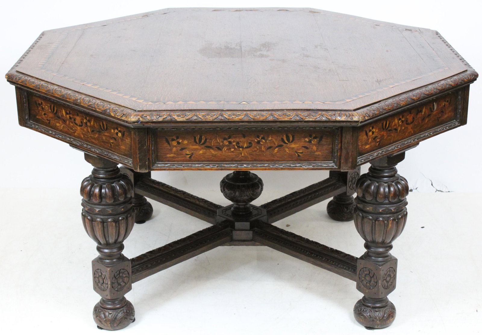 Edwards & Roberts English Revival Center Table: English oak Jacobean Revival center table. Octagon oak top with saw tooth banded inlay, dragoon carved edge. 4 real drawers with alternating 4 false drawers. Fine floral inlaid drawer fronts. Base wit