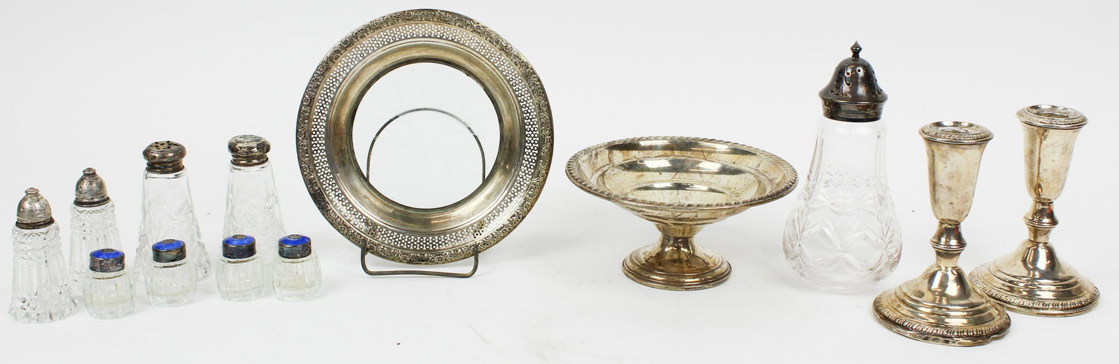 Group of Sterling Silver and Cut Glass Tableware: Lot of sterling silver and cut glass tableware including pair of gadrooned low candlesticks, banded bottle coaster, 4 barrell form salt and pepper shakers with blue enameled caps, small compote, 2 pai