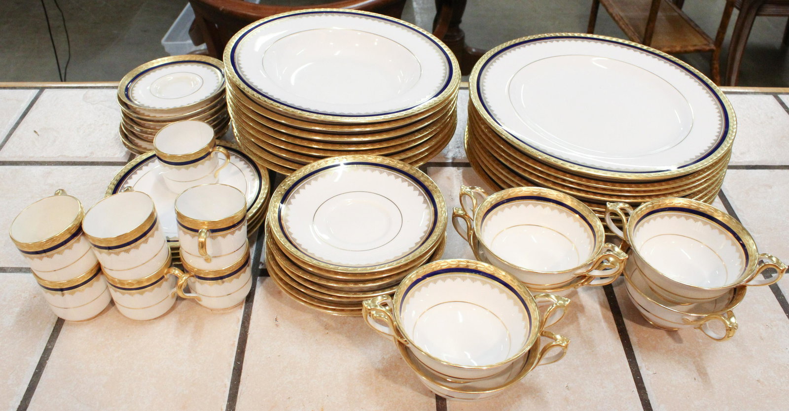 49 pcs. Spode Cobalt and Gilt Rim Dinnerware: 49 pcs. fine Spode English bone china porcelain dinnerware having cobalt band borders and gilt raised enamel laurel rim, including dinner plates, soup bowls, double handled bouillon soups, demitasse c