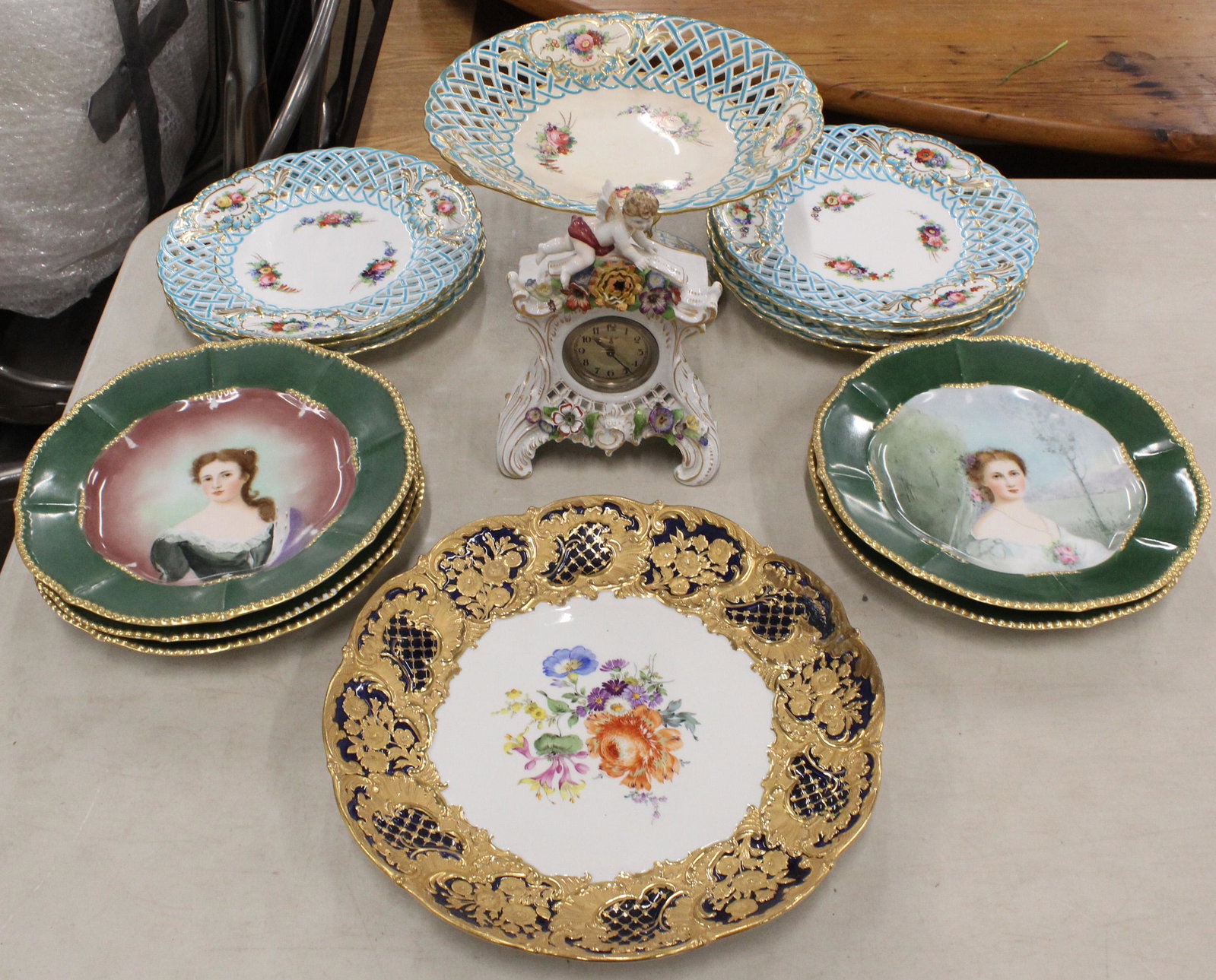 Group of Fine European Porcelain Items: Group of fine European Porcelain items including 7 Minton Dresden style reticulated luncheon plates with matching comp0te (damaged and repaired), Dresden style china case mantel clock (some losses), 5