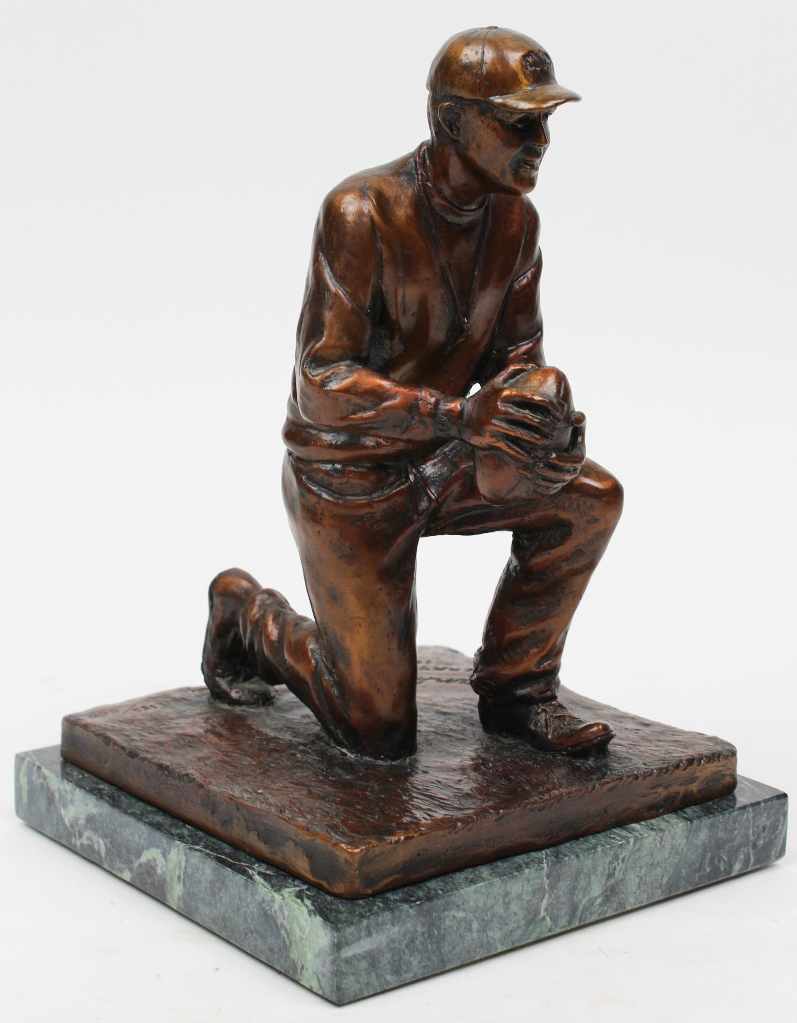 Bronze of Frank Leahy by Jerry McKenna: Bronze sculpture of Notre Dame football coach & Football Hall of Fame Frank Leahy. Cast bronze sculpture on green marble base of a kneeling Frank Leahy holding a football. This is the same image of th