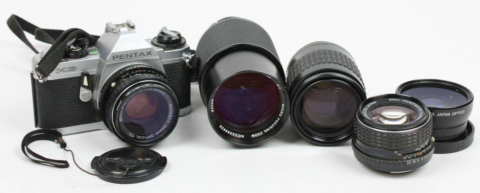 Pentax MG Camera with extra lenses: Pentax MG 35 mm film camera, SMC Pentax-M 1:2 50mm lens, SMC Pentax-M 1:1.4 50mm lens, Takumar Bayonet 1:2.8 135mm lens, Vivitar 1:3.8 75-205mm Macro focusing zoom lens, Vivitar UV 52mm macro lens