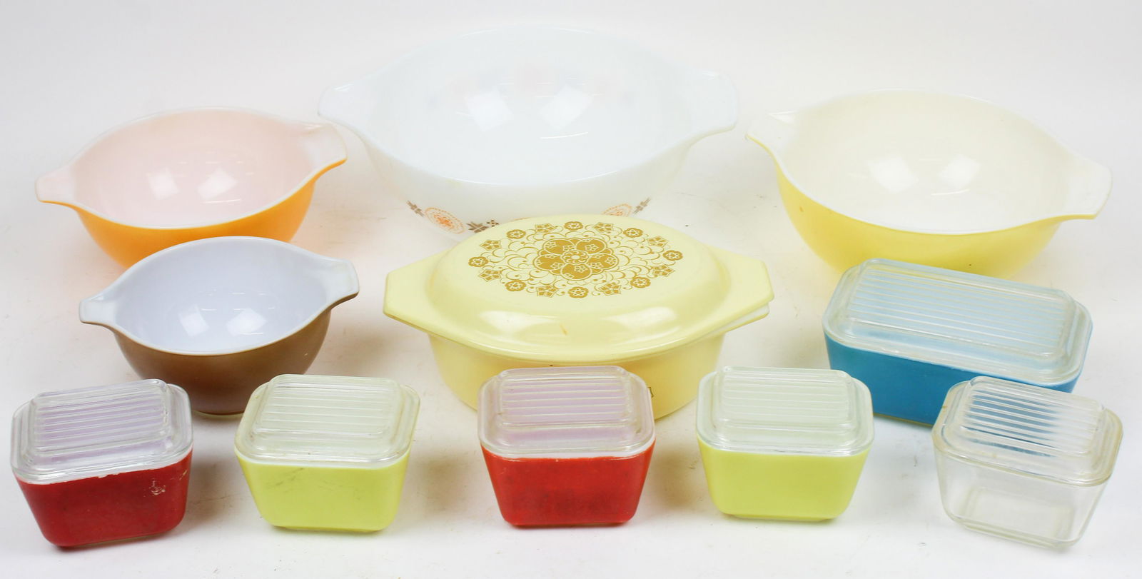 Lot of Vintage Pyrex Kitchen Glassware: Lot of vintage Pyrex kitchen glassware including nest of 4 mixing bowls, covered baking dish, and 6 primary colors refrigerator storage covered dishes -some lids with roughness, wear from use