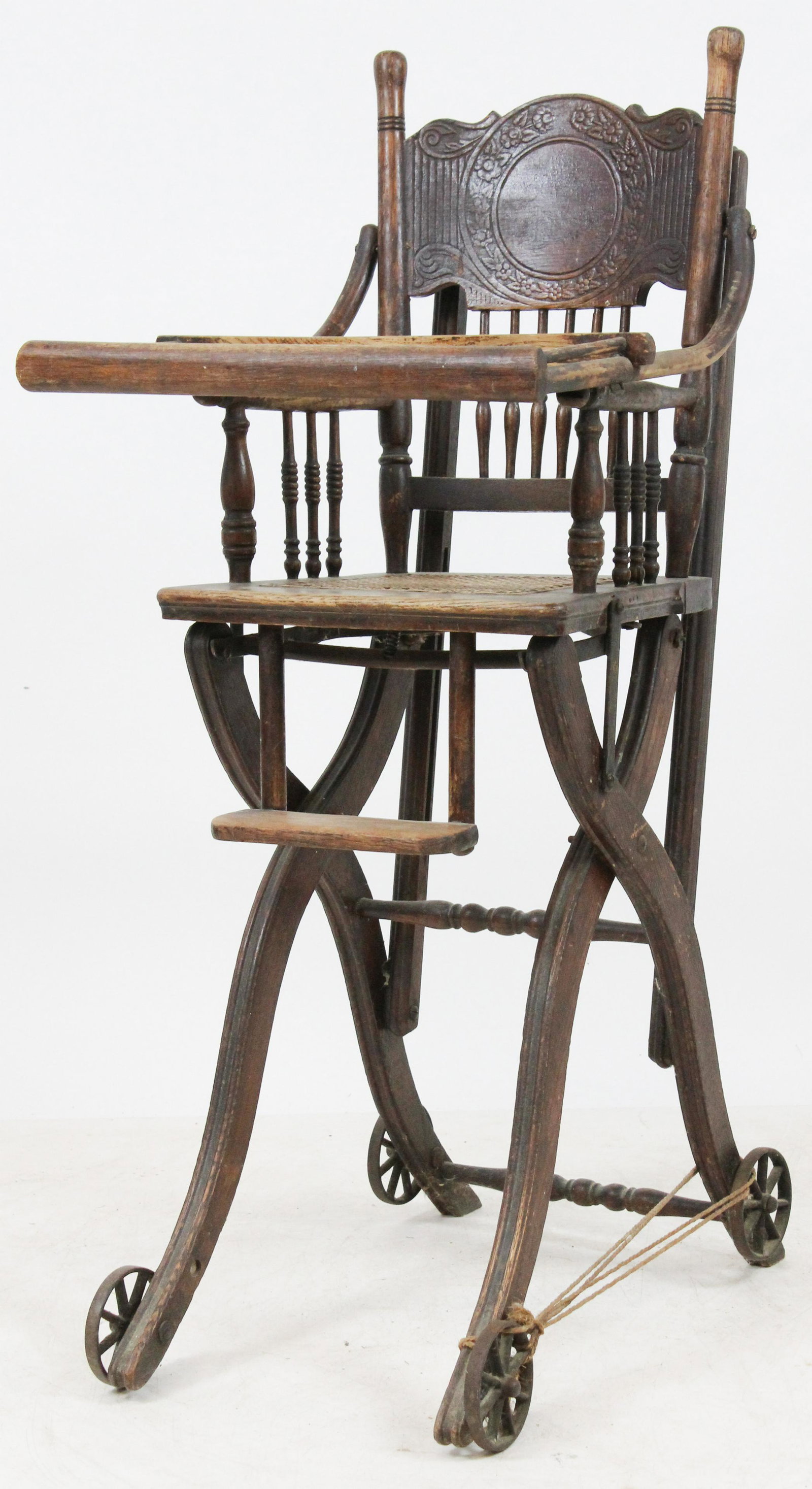 Victorian Press Back High Chair and Piano Stool: Victorian ornate press back oak convertible high chair/rocker/stroller in worn original finish, accompanied by a mahogany stained birch piano stool with spindle back on brass and glass ball and claw f