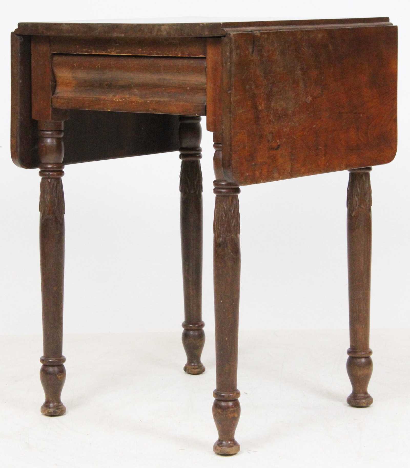 VT Sheraton Carved Drop Leaf Stand: A Vermont Sheraton cherry drop leaf work table. Rolled mahogany veneered drawer front, turned legs with acanthus carving. Old surface. 19" x 19" x 28" high.