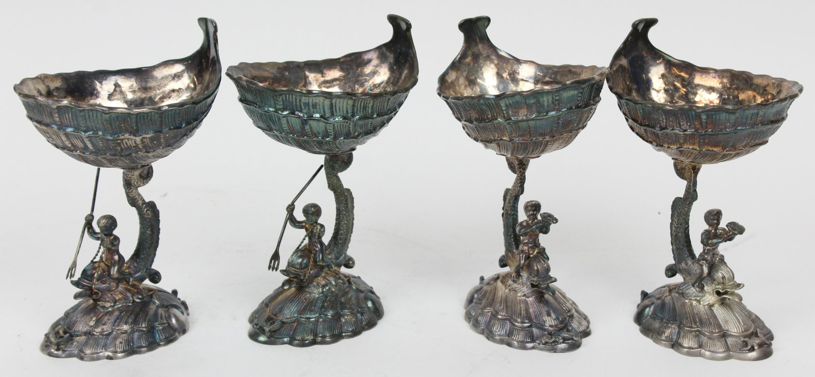 4 Ellis Barker Figural Dolphin Salt Cellars: Set of 4 finely detailed Ellis Barker silver plate figural stemmed salt cellars or cocktail dishes, having shell form base and bowl supported b y cherubs riding dolphins, menorah hallmark on reverse 6