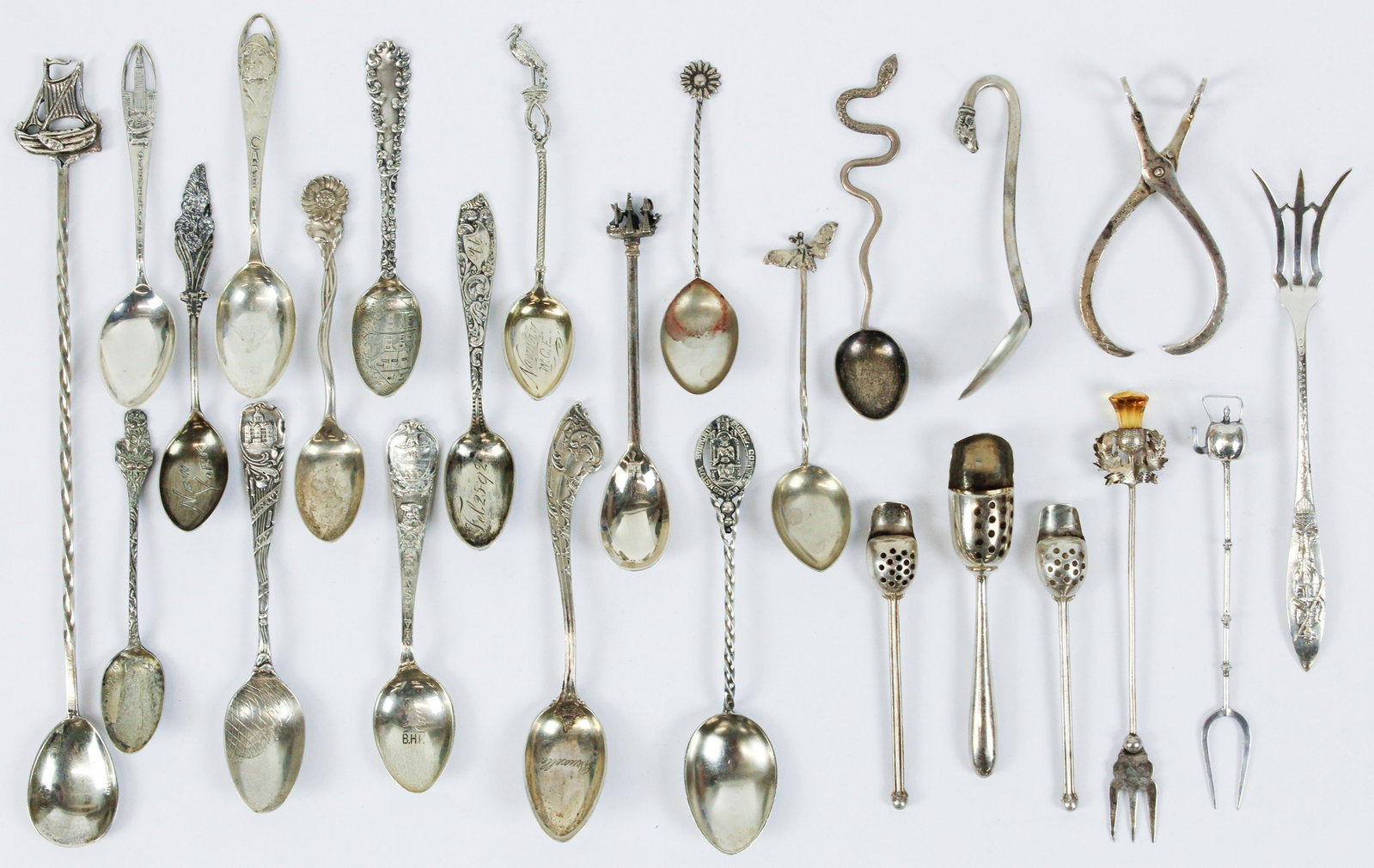 24 pcs. Mixed Sterling and Coin Silver Items: 24 pcs. mixed sterling and coin silver souvenir spoons and small serving flatware including lemon forks, sugar tongs, 3 snuff scoops, etc. -some with European hallmarks of various grades, approximatel