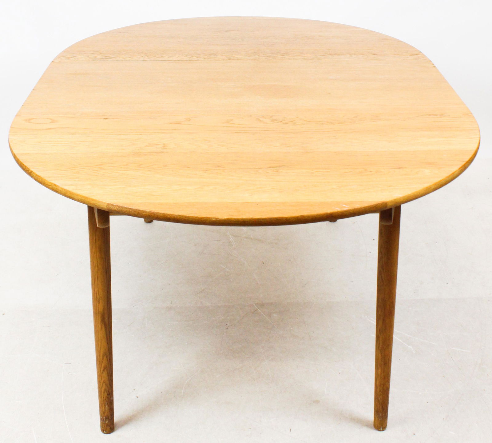 Andreas Tuck, Denmark Hans Wegner Design Table: Hans Wegner for Andreas Tuck, Denmark oak dining table with three leaves, stamped on underside, top diameter 47", three leaves each 19 1/2", total length 106" (just under 9)