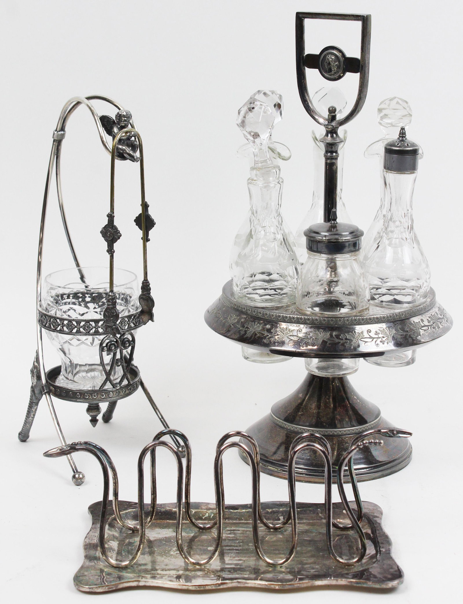 Unusual Silverplate Tableware incl. Los Castillos: Group of 3 pcs. of silver plated tableware including Los Castillos Emilia Castillo snake motif Mexican silver-plated toast rack and undertray, Victorian caster set with wheel etched cruets, and cut gl