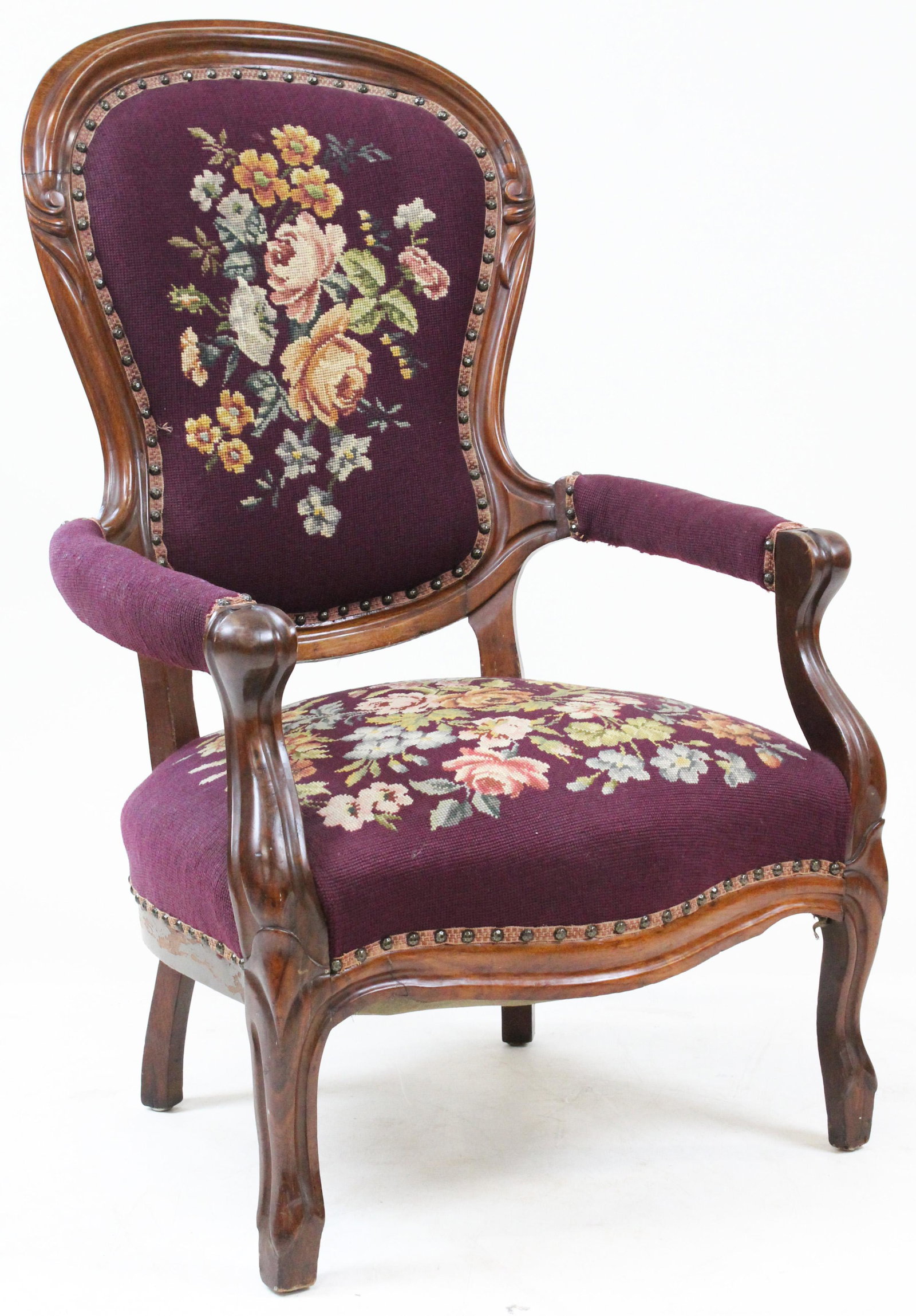 Victorian Gents Chair in Needlepoint Upholstery: Victorian rococo style black walnut finger carved gent's armchair with balloon back and cabriole legs, in eggplant colored floral needlepoint upholstery 41" x 25" x 22"