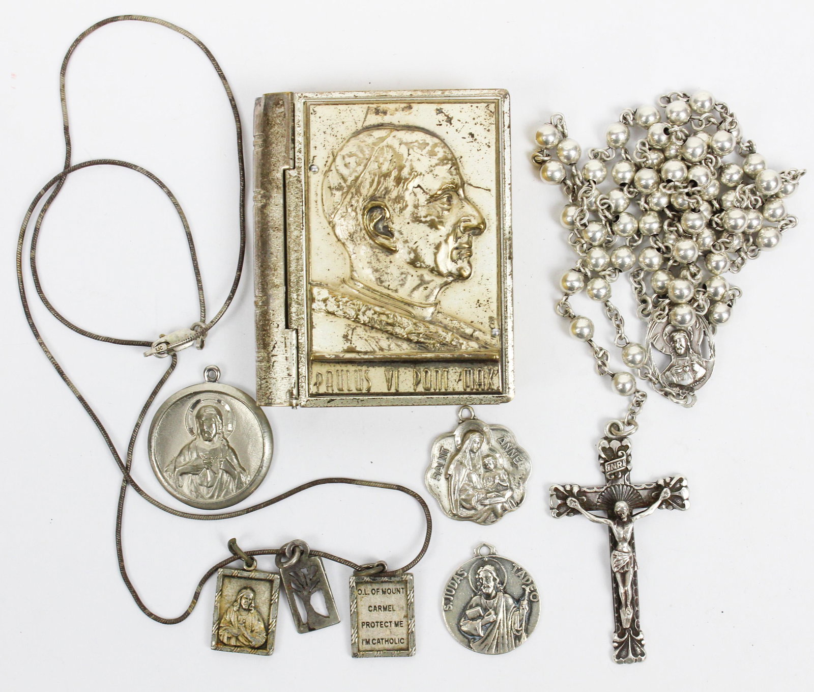 Sterling Catholic Relics: A group of sterling Catholic items including a silver Paulus VI Pont Max book, Mexican silver cross, and more.