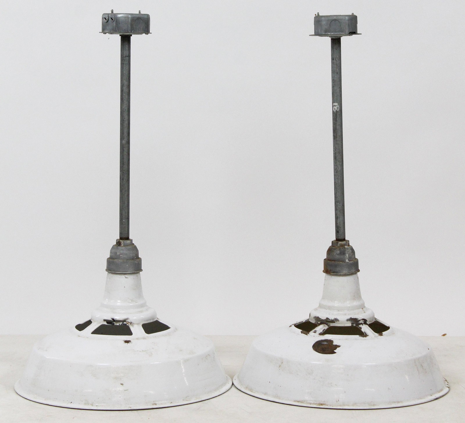 Pair of Industrial Enamel Hanging Lights: Pair of Industrial hanging lamps with white enamel shades (few chips), diameter 18"