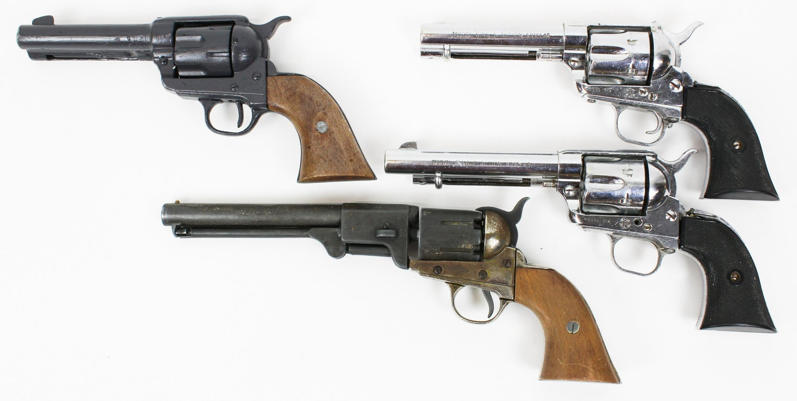Group of Four Metal Replica Revolver Cap Guns: 2 BKA colt revolver replicas with wood grips and metal bodys. 11 and 14 inches in length respectively. Smaller of the two has been painted over on metal areas. In reasonably good condition otherwise. 