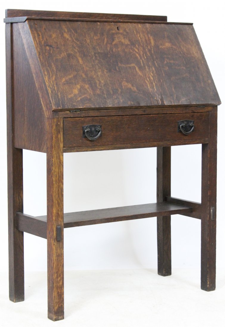 Stickley Slant Front Desk: Stickley oak slant front desk. Drop front, fitted interior with drawer, over single drawer and lower shelf. Old finish, original hardware. Shows red Stickley clamp mark inside drawer, retailer label o