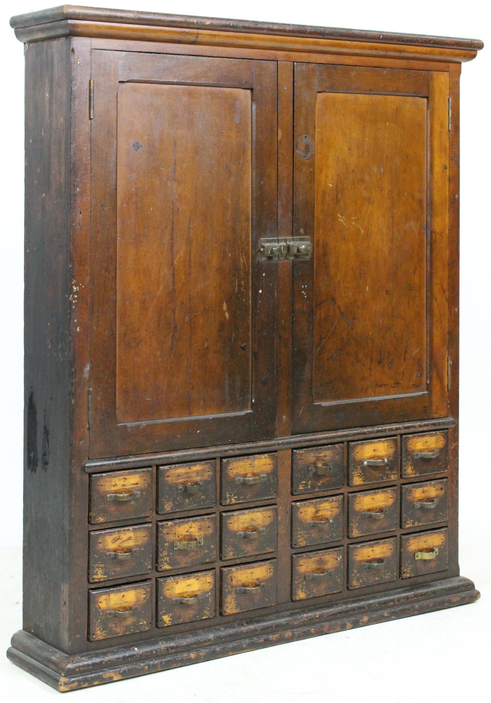 19th c. Apothecary Hanging Cabinet with 18 Drawers: Fine late 19th c. basswood hanging apothecary type cabinet with 2 latch cupboard doors revealing slanted compartments, over 18 mortise and tenon constructed divided drawers, in old original surface 39
