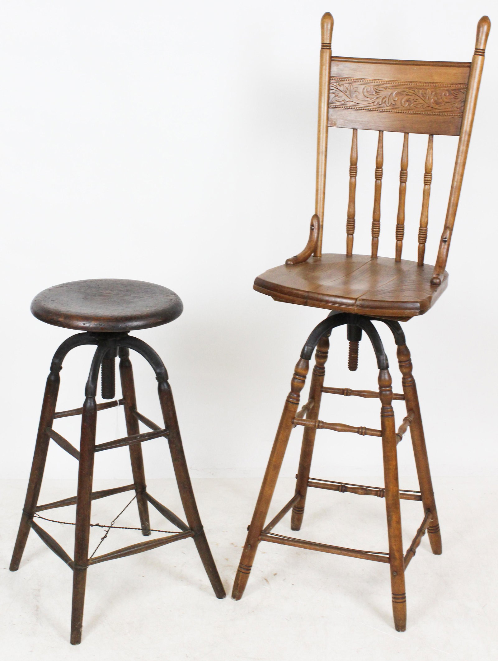 2 ca. 1900 Cast Iron and Wooden Swivel Stools: 2 ca. 1900 wooden telephone operator type stools with swivel seats and cast iron hardware, one with spindle and press carved back. old metal reinforcements ht. 30", 55"