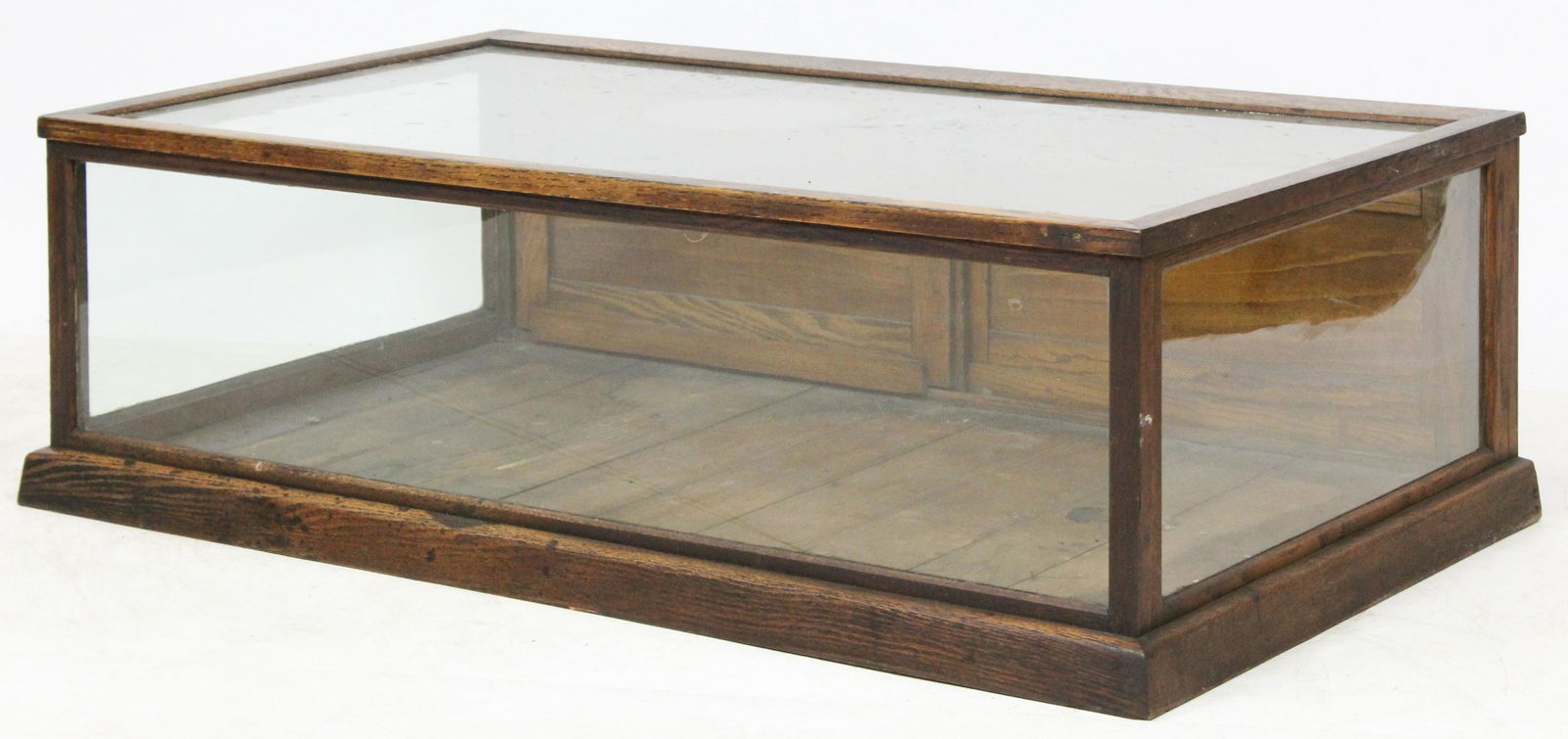 Countertop Display Case w/ Sliding Wood Panel Door: Has glass panels on three sides, with a sliding wood door on the back of the piece. Top is also made of glass for display purposes. No major damage, piece is in very good shape. H: 14 1/2 in. L: 44 1/