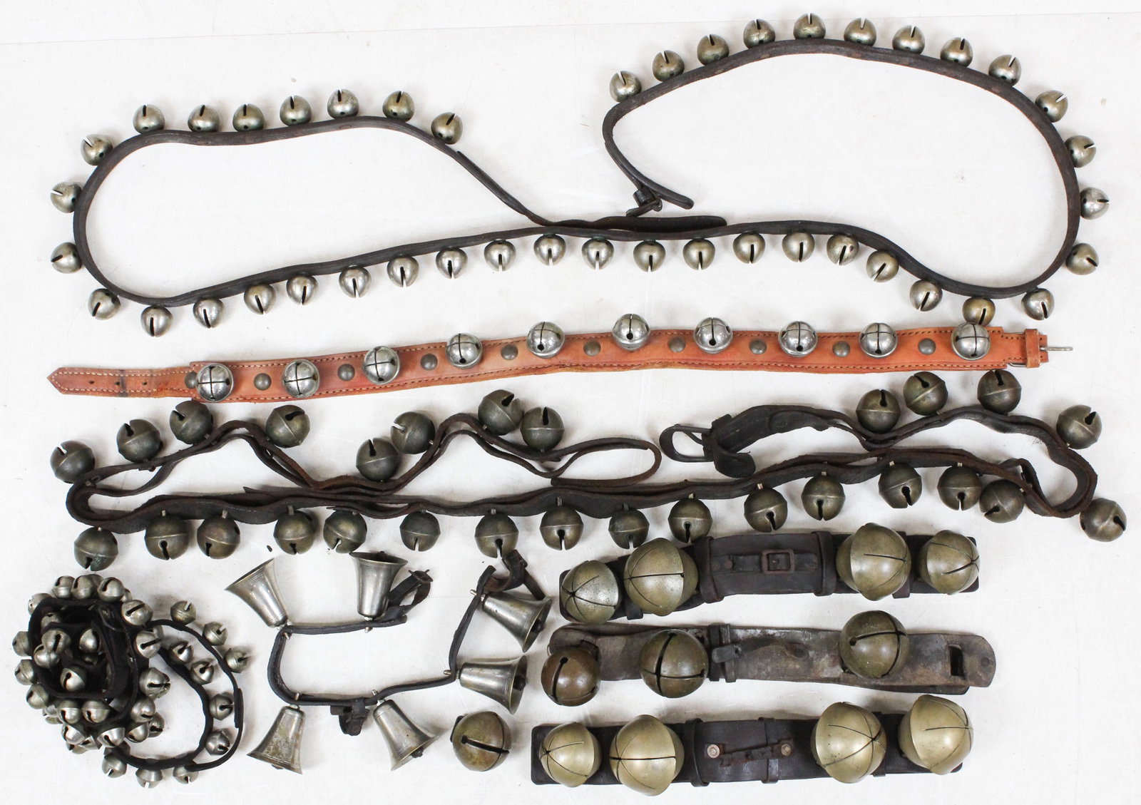 Large lot of Assorted Sleigh Bells: Lot of assorted 19th-mid 20th c. sleigh bells including large brass bells, nickel plated, etc., or varying lengths, approx. 16"-80" -some with deteriorating leather, 1 loose bell on old large set.