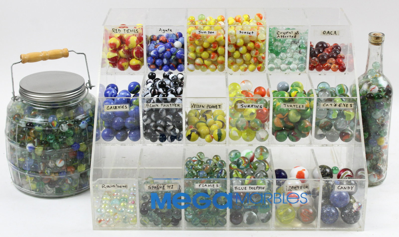 Store Display Rack of Assorted Glass Marbles: "Mega Marbles by Vacor USA" acrylic hobby store countertop display rack filled with an assortment of colorful glass marbles of varying sizes including shooters, cat's eye swirls etc., accompanied by a