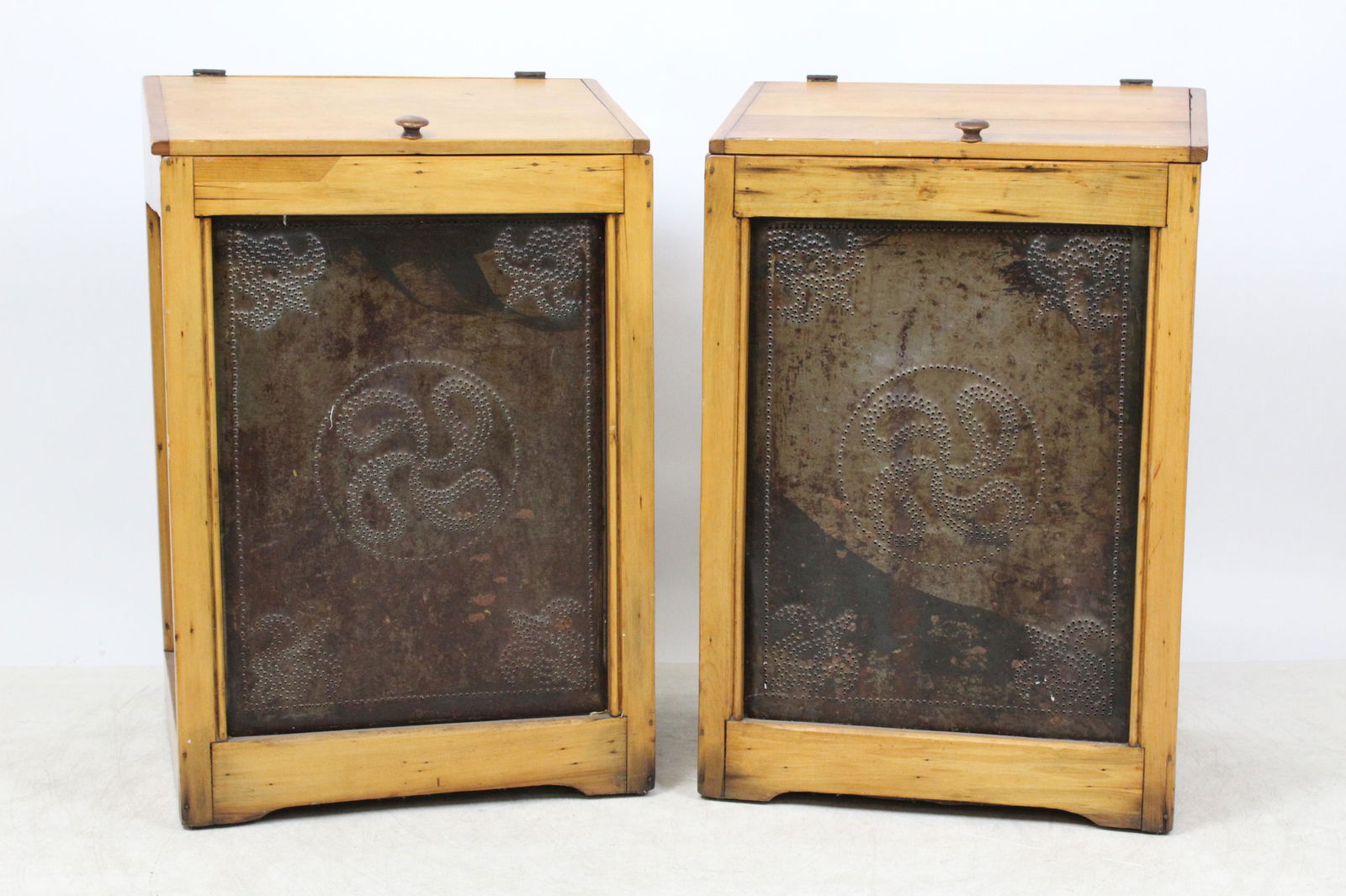 Pair Pierced Tin Flower Bins: A pair of late 19th c slant top pine flower bins. 3 sides with pierced tin panels with pin wheel designs. Refinished. Traces of old red paint under bases. Nailed construction, old repairs, very refini