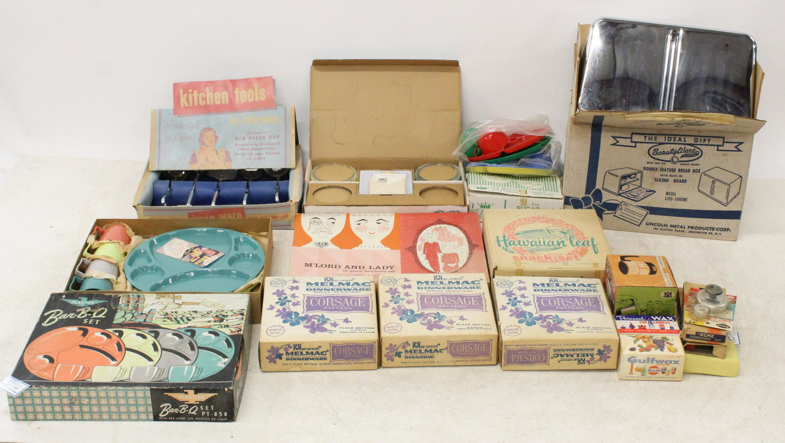 Group of New Old Stock Kitchenware: Group of new old stock 1950's-60's kitchenware including set of Glasbake Patioware individual casseroles, Hawaiian Leaf Snack set, Melmac place settings, set of chrome kitchen tools, bread box, etc.
