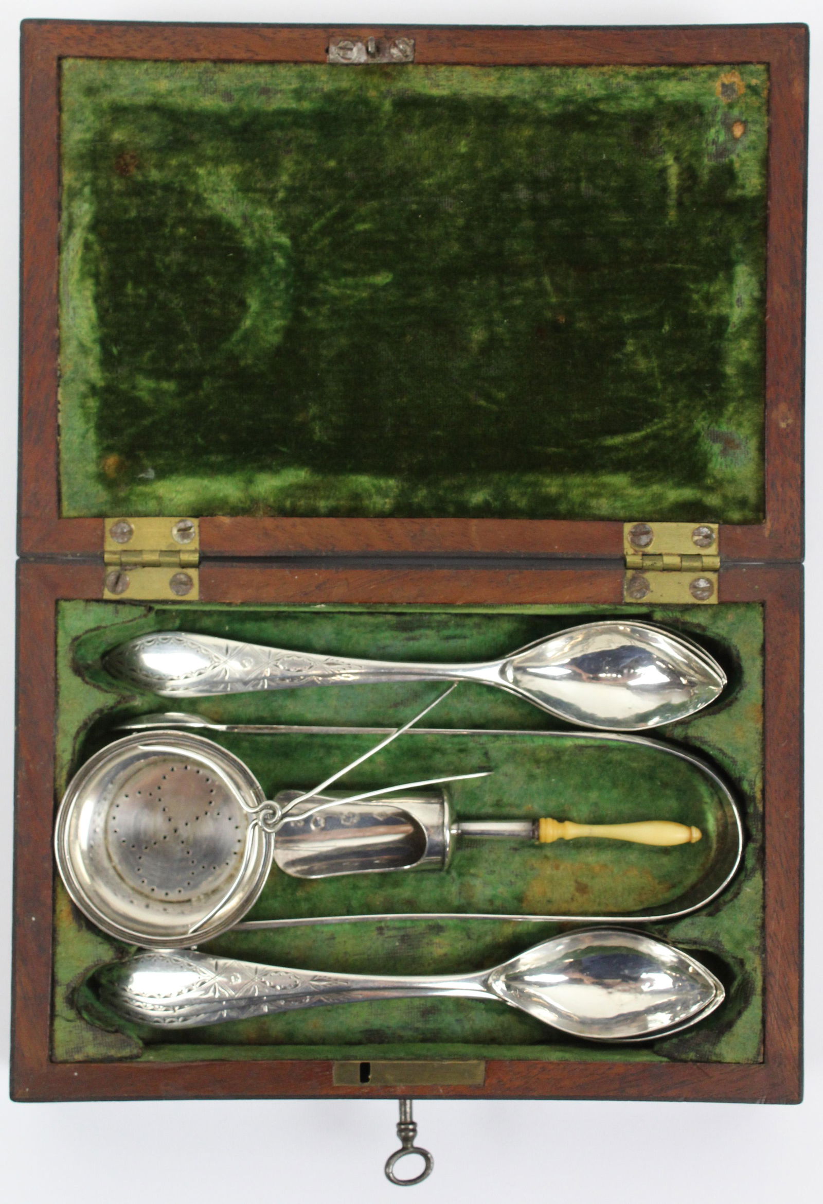 1816 Dutch Coin Silver Tea Serving Set in Case: 1816 Dutch 835 coin silver tea serving set consisting of 9 teaspoons, sugar tongs, tea caddy scoop with bone handle, and strainer, all having hand chased neoclassical decoration, in emerald green velo