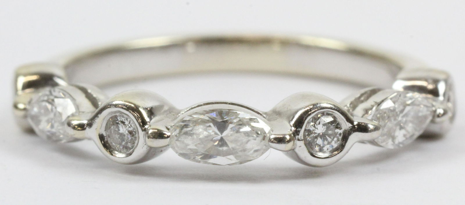 Diamond & 14k Wedding Band: A 14k white gold wedding ring set with 4 round cut bezel set .04 ct diamonds each separated by 3 marquise cut diamonds each .08 cts. 1/2 ct t.w. diamonds. Ring size 7.