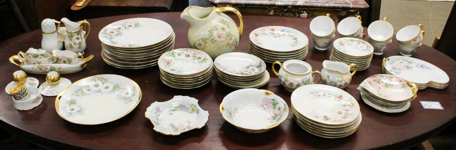 85 pcs. Hand Painted Floral Dinnerware: 85 pcs. of early 20th c. porcelain tableware with handpainted floral wild rose decoration, many items artist signed, on blanks including Limoges, Bavarian and Japanese and other assorted manufacturers