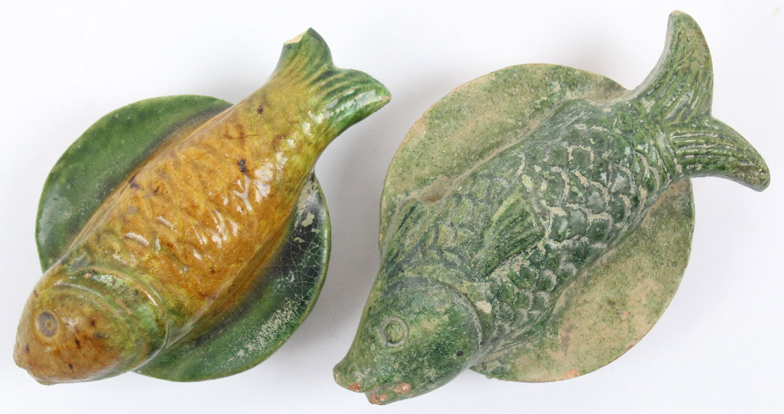 Two Chinese Han Dynasty Sancai Glazed Fish: Two Chinese Han Dynasty (206 BC to 220 AD) Sancai glazed pottery fish (sometimes known as â€œspirit utensils” or â€œvessels for ghosts") , one with small chip on tail, lengths 3 3/4" to