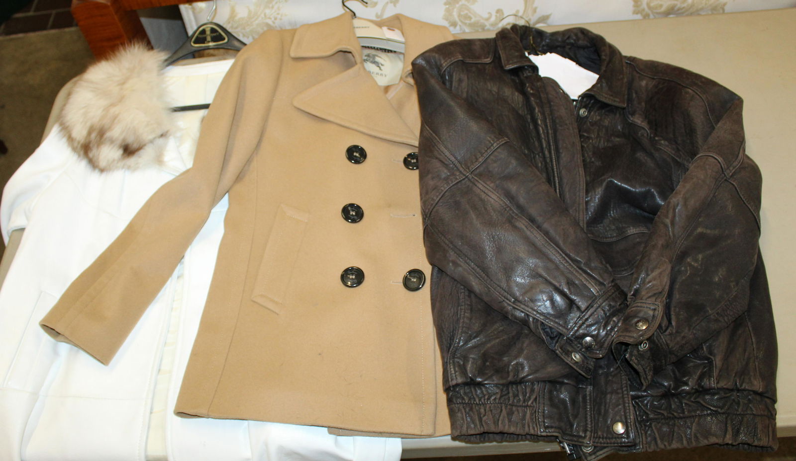 Group of 3 Coats incl. Burberry, Leather: Group of 3 vintage coats including a medium Burberry London tan camel hair type felt peacoat, 1960's fur collared white naugahyde ladies coat, and a small men's 1980's leather bomber jacket -sold to b