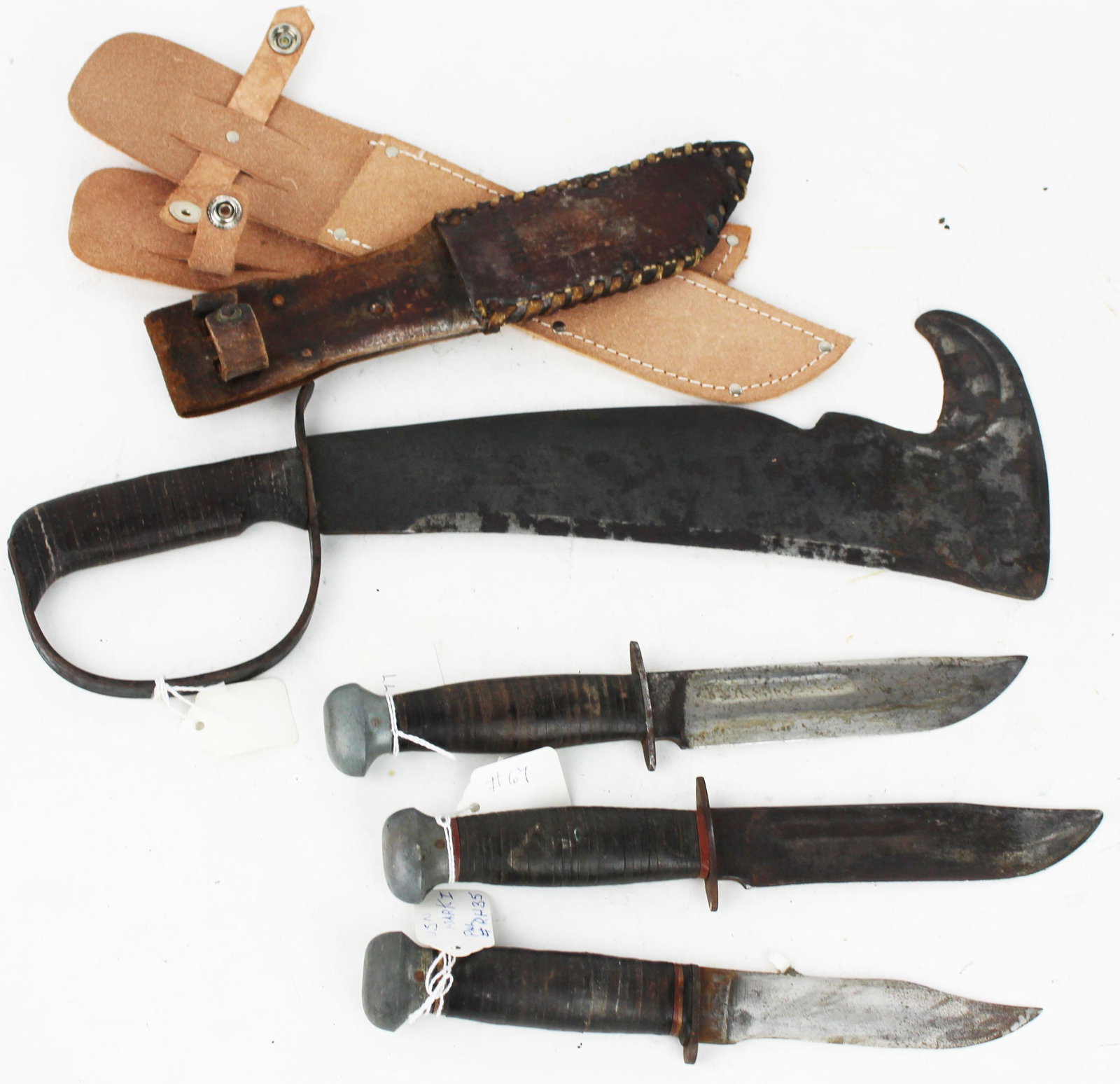Four WWII Era Knives: Two Remington RH 36 Pal fighting or hunting knives 6.5" blades 11" overall, a Woodsman's Pal Brush tool 12" blade 16.5" overall; Pal RH 35 USN Mark 1 fighting knife ground down 5.5" blade 10" overall