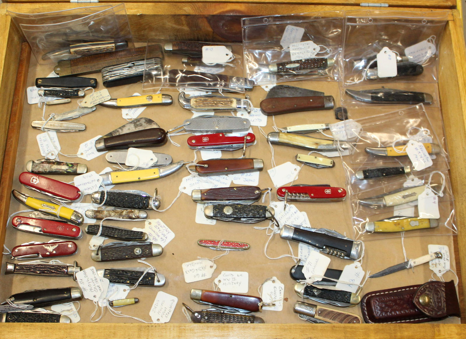 Large lot of pocket knives: Approximately 65 Pocket knives of various makes and types in homemade pine case with individual collectors tags on each lovingly describing origin and manufacture.