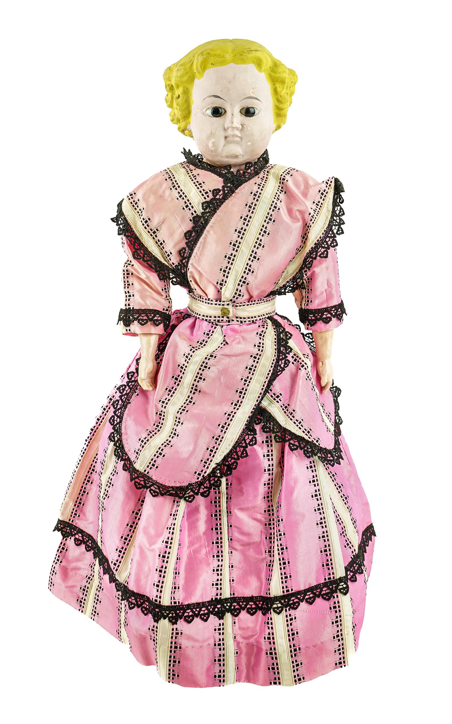 Ca. 1860 Composition Glass Eye Doll: Ca. 1860 molded composition doll with brown glass eyes, blonde molded hair, composition hands and feet with blue painted boots. Period pink satin dress and undergarments. 22" h. Small flake to left si