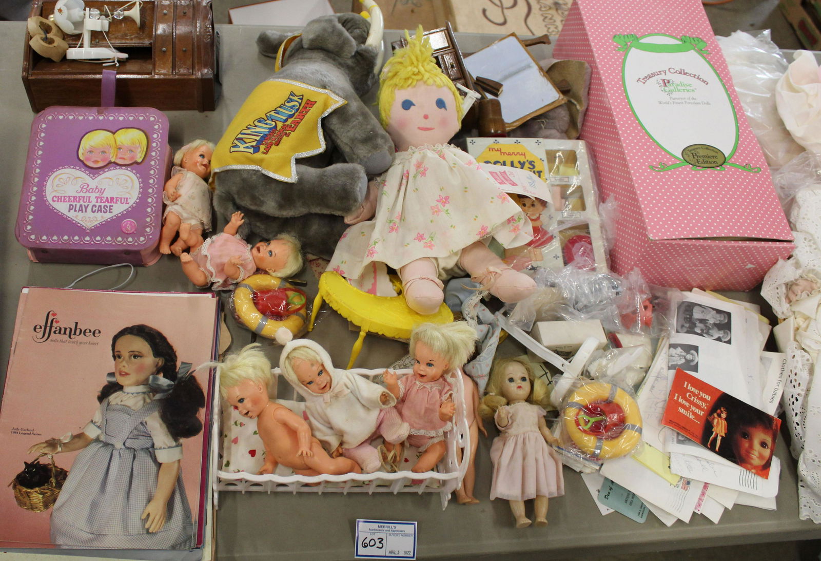 Table Lot of Dolls and Accessories: Table lot of dolls and accessories, including 1979-1985 Effanbee catalogues, Norman Rockwell character doll, group of Baby Cheerful tearful dolls and accessories, King Tusk plush toy, porcelain Gerber