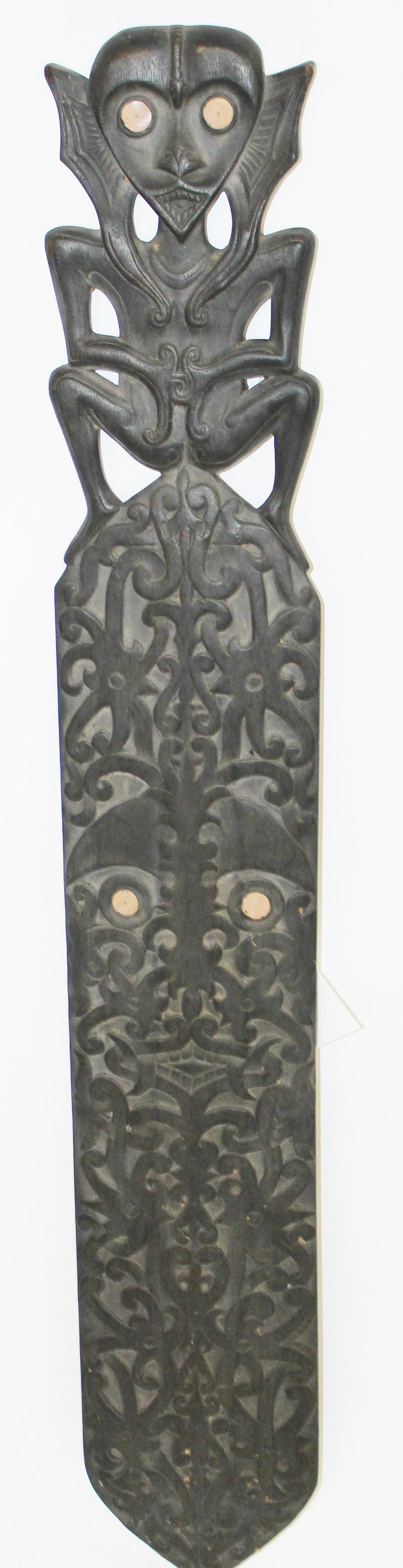 Melanesian Shield with Stylized figure: late 20th c Melanesian Shield with stylized spirit figure at top and fanged maw center. 51 x 9"