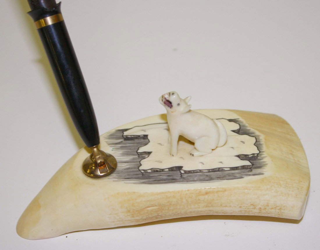 Inuit whale tooth pen holder featuring dog howling: Inuit whale tooth pen holder featuring dog howling on iceflow