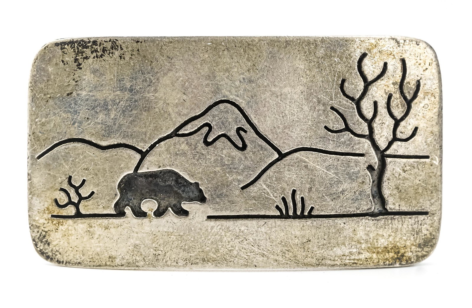 Navajo Silver Belt Buckle: Navajo sterling belt buckle with deep engraved scene of bear, mountain, & tree. 2 1/8" x 1 1/4".