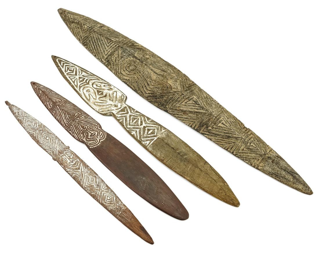 Four Wooden Bullroarers: Four Papua New Guinea carved wooden bullroarer instruments. White pigments, carved geometric designs. 16.5"-27.5"