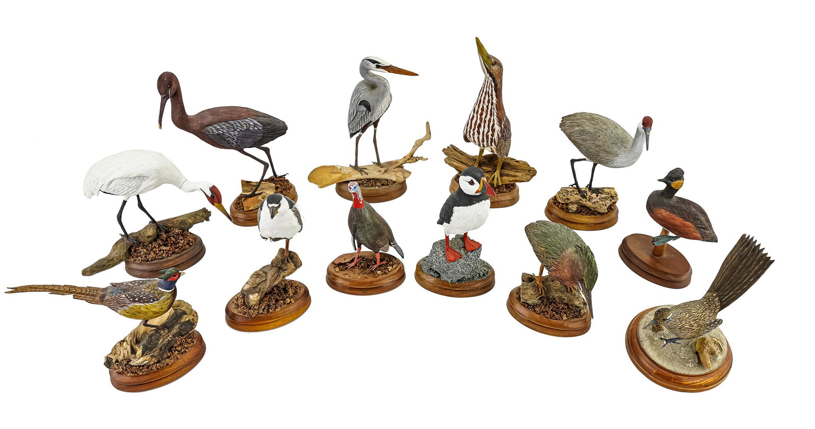 12 Miniature Wilkinson Bird Carvings: A group of 12 miniature bird carvings by Jim and Diane Wilkinson including cranes, fisher, and game birds. 11" to 5" high. 6 with chips or repairs.