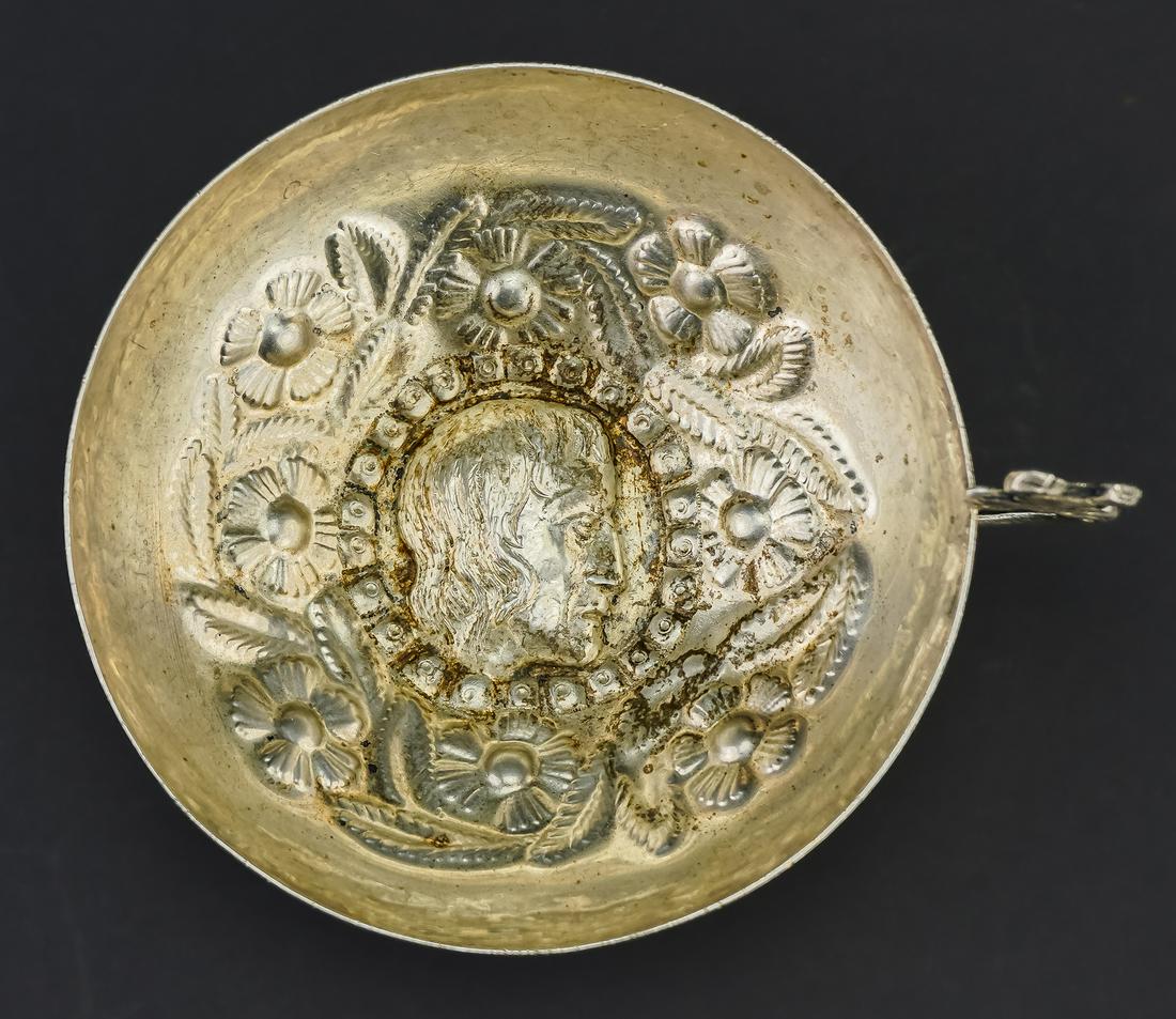 Silver Repousse Figural Wine Tasting Cup: Peruvian or South American floral repousse tastevin wine tasting cup having figural portrait center and bird handle, unmarked, tests as 800 coin silver 1.75"-6.25" 5.5 troy oz.