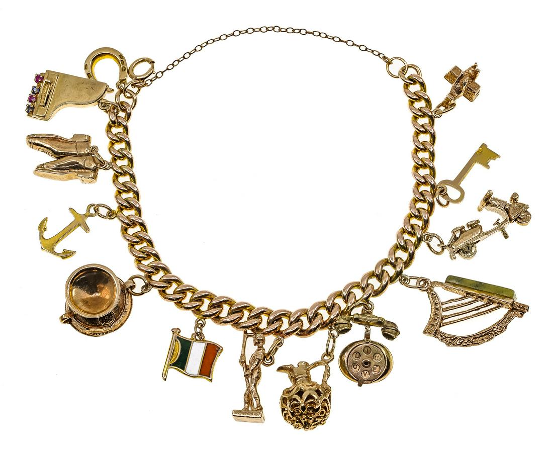 Yellow Gold Charm Bracelet: 10k yellow gold charm heavy link bracelet with 12 charms in 10 & 14k of harp, piano, shoes, cup, soldier, flag, ewer, and others. 53.7 grams t.w.