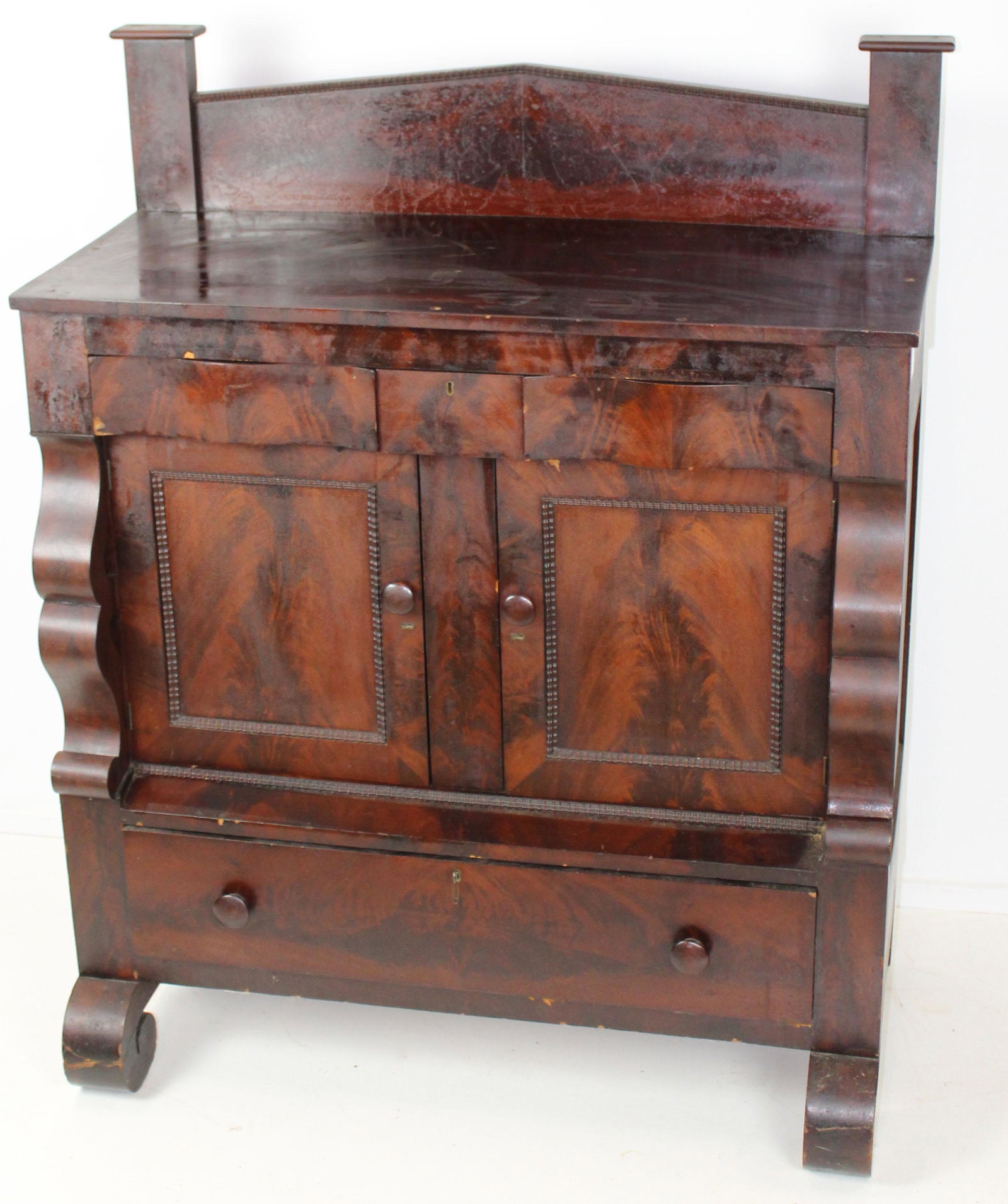 Empire Mahogany Half Sideboard: Empire mahogany half sideboard, with Federal backsplash, 3 drawers over two doors over long drawer, rolled feet, ribbon molding, 43" x 19" x 55"