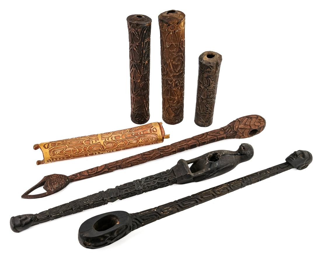 Seven Asmat Carvings: Three well carved Asmat axe and mallet handles, and four bamboo "Fu" trumpets(sometimes called headhunting trumpets). All are carved with classic Asmat designs. One trumpet is not completely hollowed 