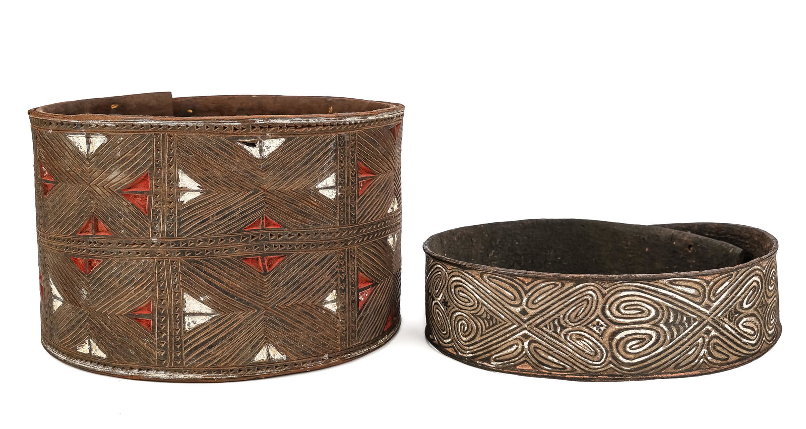 Two Papuan Bark Dance Belts: Two fine examples of bark carved belt adornments from Papua New Guinea. Large Sepik River carved belt with geometric patterns, lime and natural pigments, one carved and painted belt with ancestor/spir