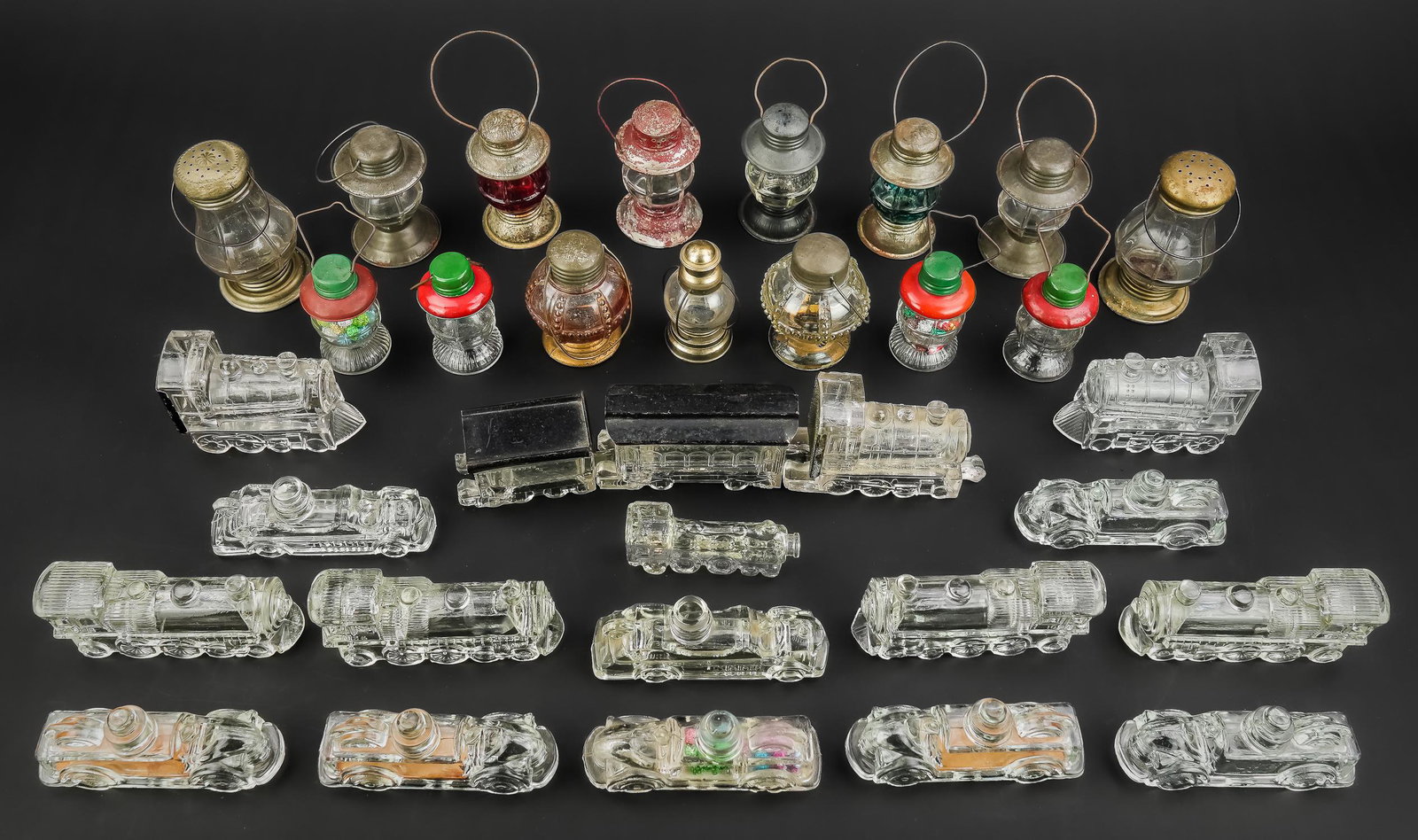 Collection of 33 Glass Candy Containers: Collection of 33 novelty form glass candy containers and related objects including 3 part linked steam locomotive, 6 locomotive engines, 8 fire engines, train engine form bottle, 15 railroad lantern f