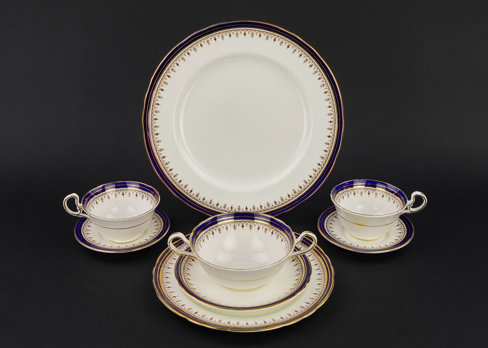 106 pcs. Aynsley Cobalt Bone China Dinnerware: 106 pcs. Aynsley cobalt blue and gold rimmed English bone china porcelain dinnerware including dinner plates, double handled soup bowls, cups and saucers, side dishes, etc.