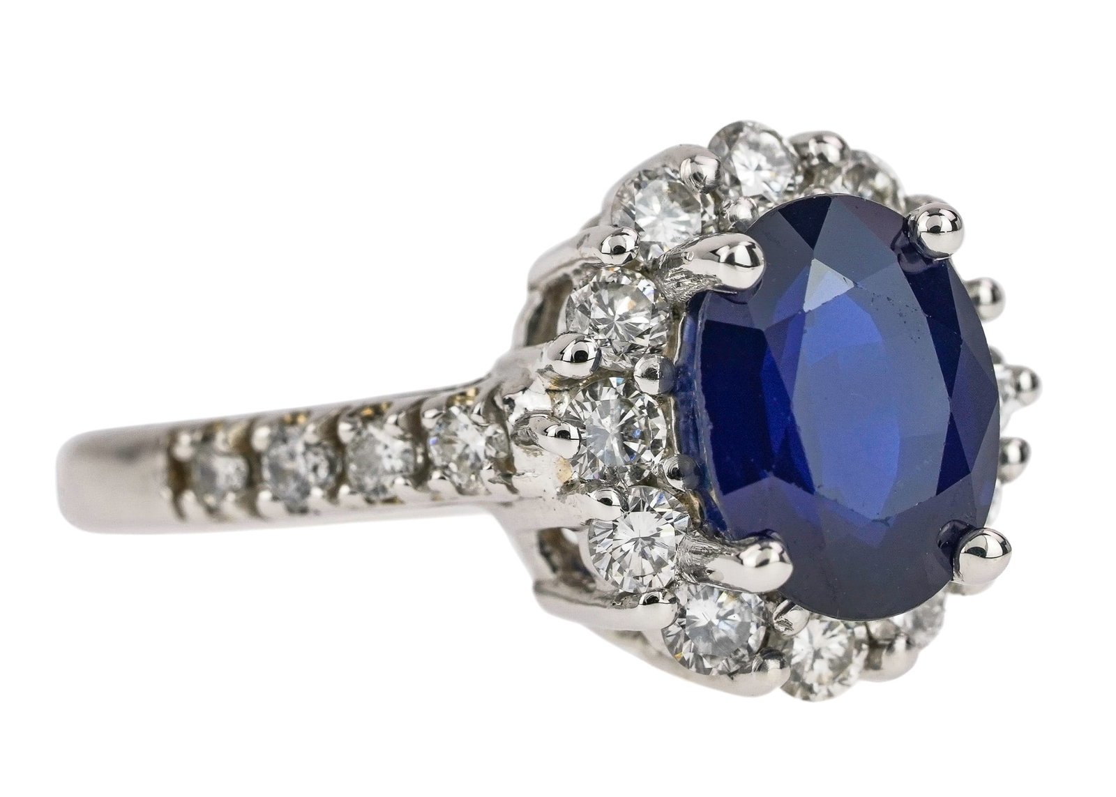 2.25 CT Sapphire & Diamond Ring: 14k white gold ring set with a 2.25 ct natural oval cut sapphire set with a 12 diamond round cut surround and a 4 round cut diamonds down each side of band. Ring size 6.5