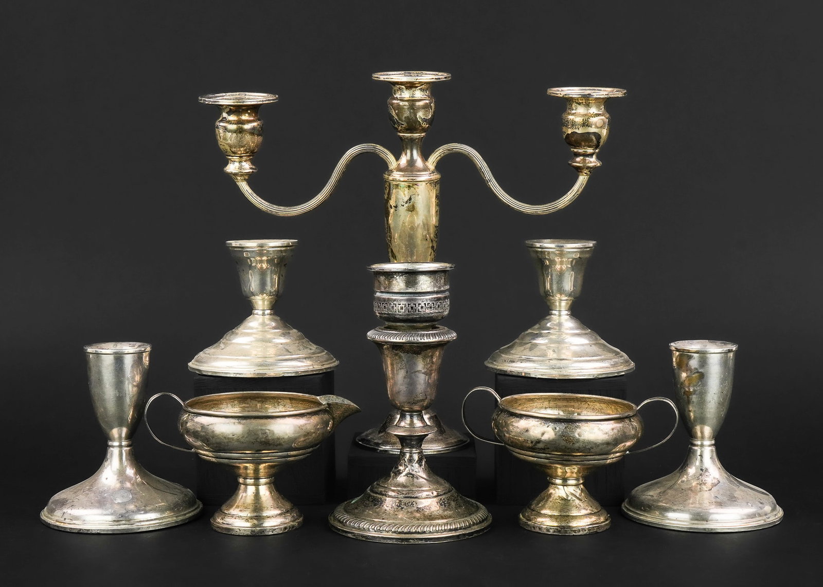 9 pcs. Sterling Silver Weighted Hollowware: Lot of 9 pcs. of weighted sterling silver hollowware including 2 pair of candlesticks, 2 single candlesticks, sugar and creamer set, damaged candelabra ht. 3.5"-6.25"