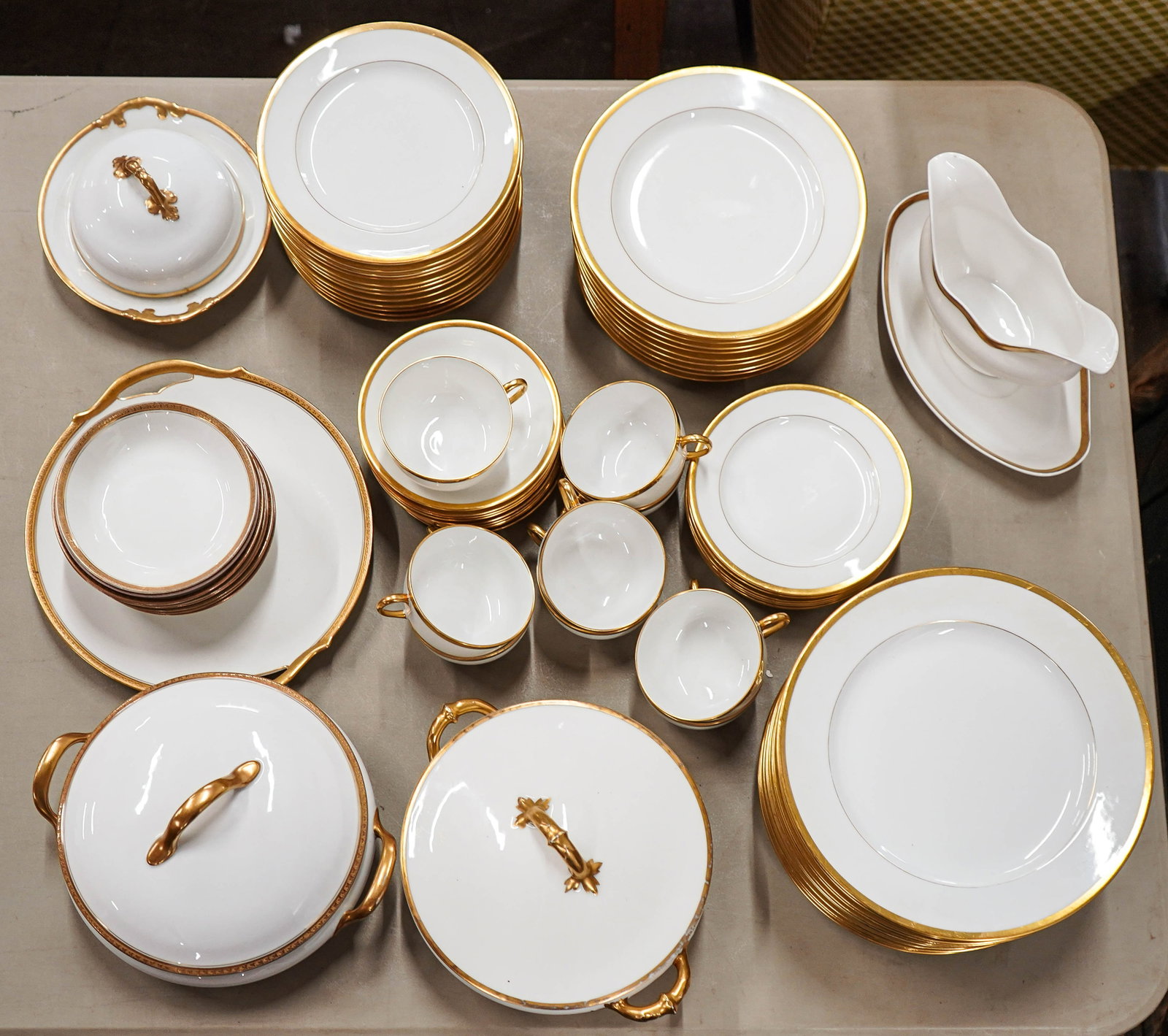 71 pcs. Limoges Gold Band Porcelain Tableware: Approx. 71 pcs. of Limoges gold band fine porcelain tableware by various manufacturers, including 12 dinner plates, 9 salad plates, 12 side plates, 8 dessert plates, 2 covered serving dishes, sauce bo