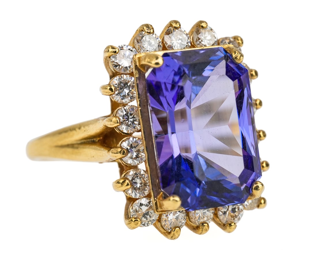 14k Diamond & 8 CT Blue Tanzanite Ring: 14k yellow gold ring with a emerald cut approx. 8 CT tanzanite with 16 .03 ct round ct diamond surround. Ring size 7.